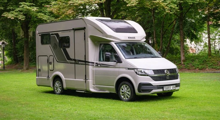 Husbil i campingmiljö på gräsmatta